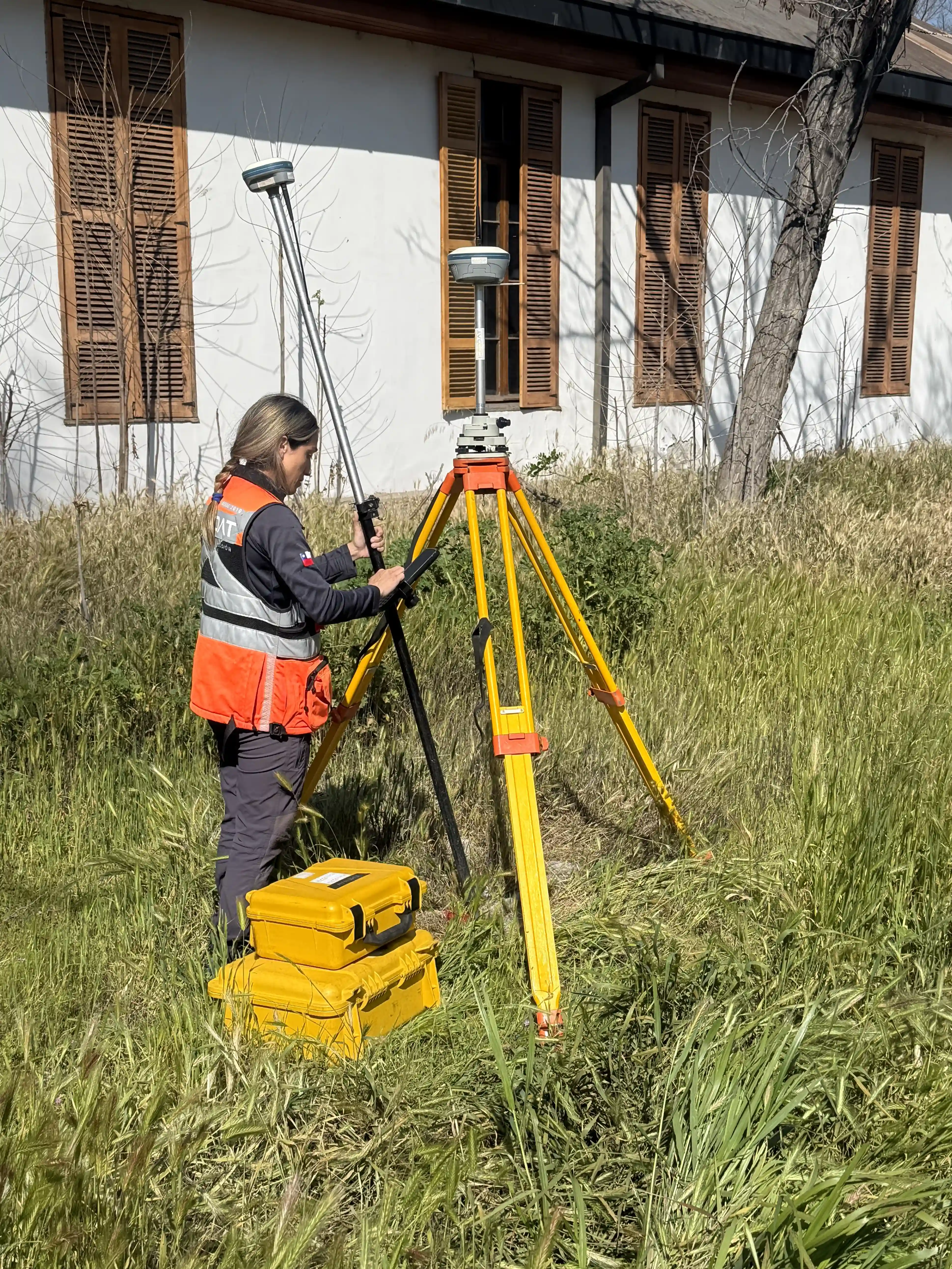 Topógrafa con teodolito en propiedad