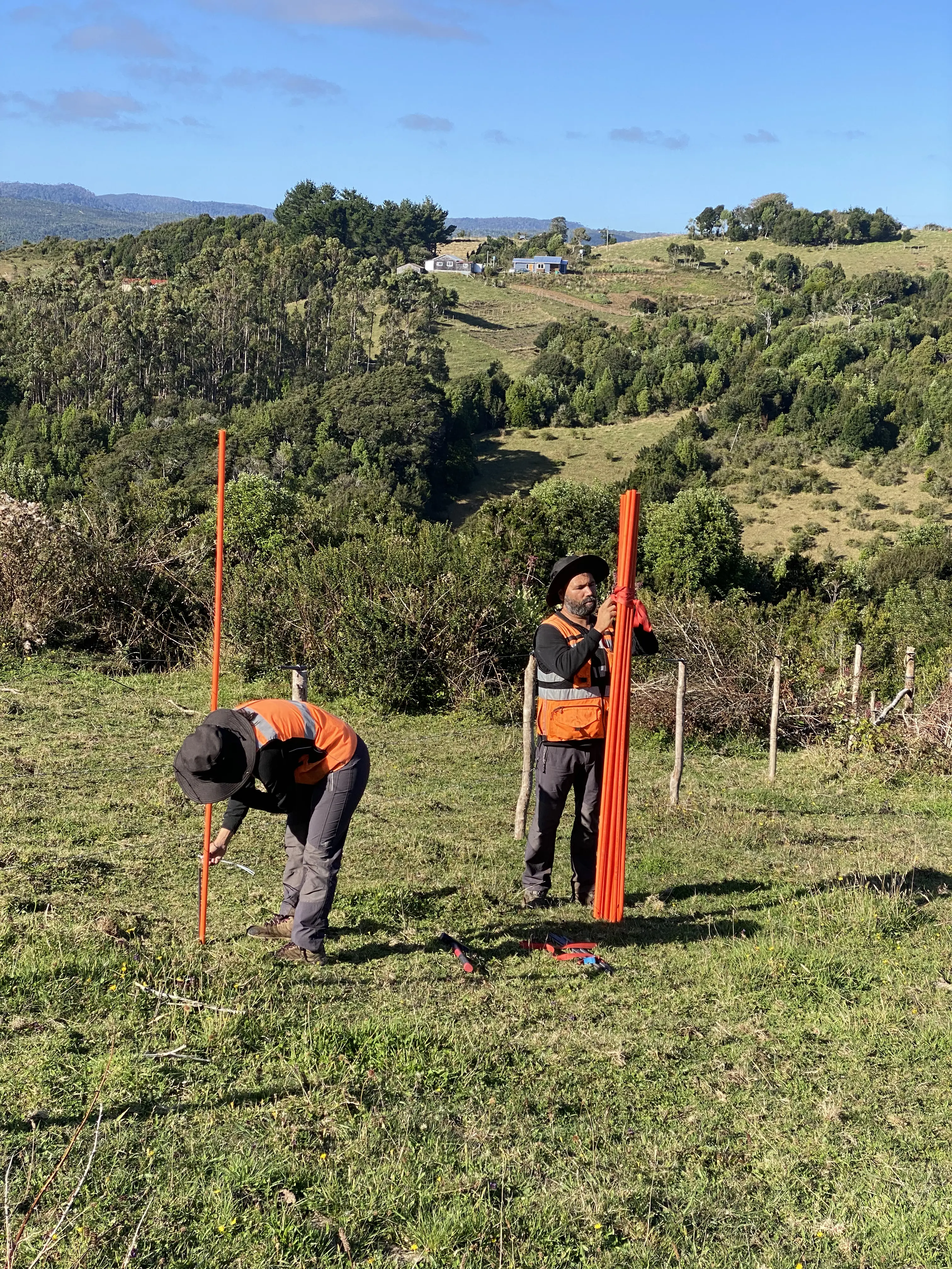 Dos topógrafos midiendo en campo abierto